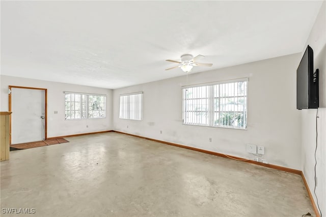 unfurnished room featuring a ceiling fan, baseboards, and concrete floors