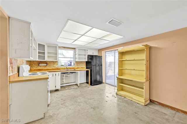 kitchen with visible vents, electric stove, open shelves, white cabinetry, and freestanding refrigerator