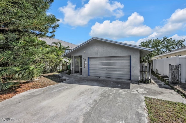 garage with driveway and fence