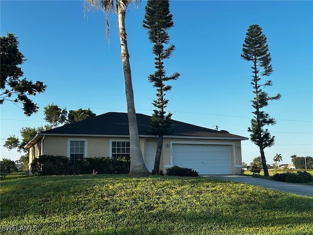 view of front of house featuring concrete driveway, a front lawn, a garage, and stucco siding