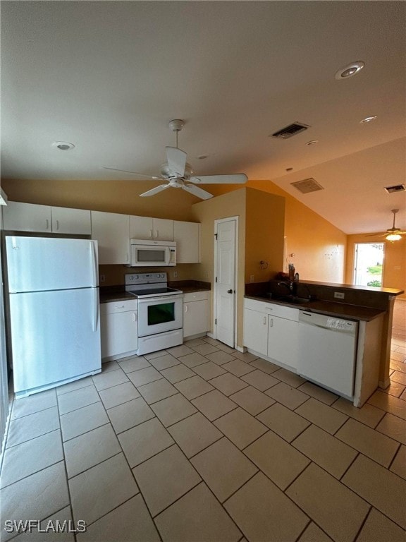 kitchen featuring white appliances, dark countertops, vaulted ceiling, and white cabinetry