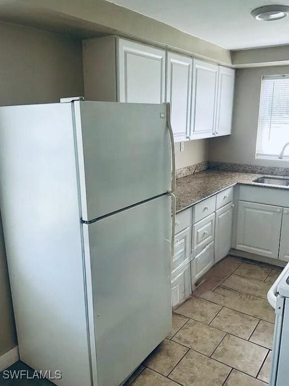 kitchen with white cabinets, white appliances, and a sink