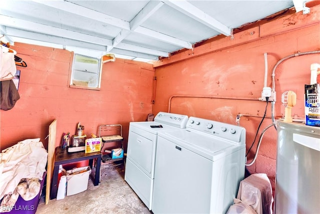 clothes washing area featuring laundry area, concrete block wall, and separate washer and dryer