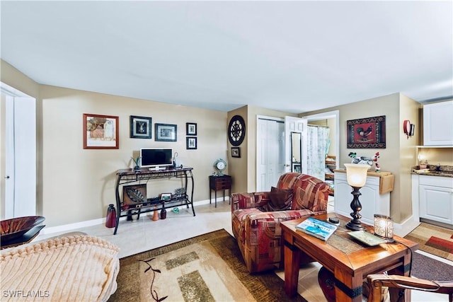 tiled living area featuring baseboards