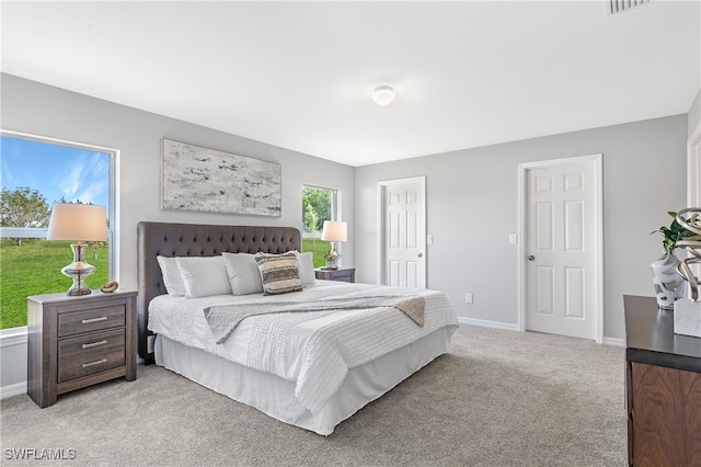 bedroom with light colored carpet and baseboards