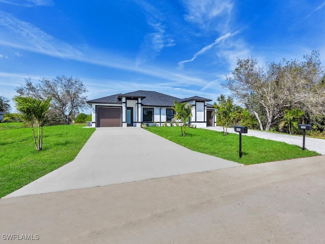 prairie-style house featuring an attached garage, concrete driveway, and a front lawn