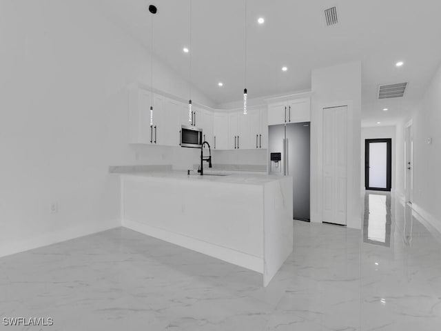 kitchen featuring visible vents, a peninsula, light countertops, appliances with stainless steel finishes, and marble finish floor