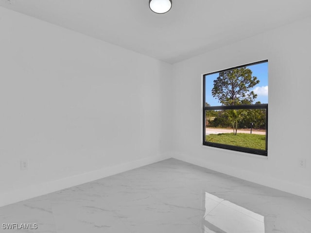 empty room featuring baseboards and marble finish floor