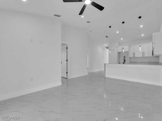 unfurnished living room with a sink, visible vents, baseboards, and marble finish floor