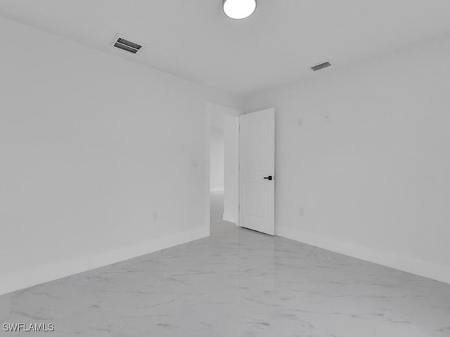 spare room with visible vents, marble finish floor, and baseboards