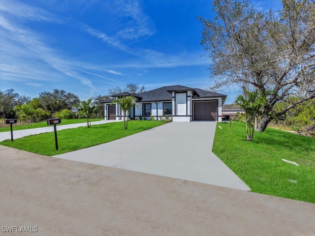 view of front of home featuring an attached garage, concrete driveway, and a front lawn