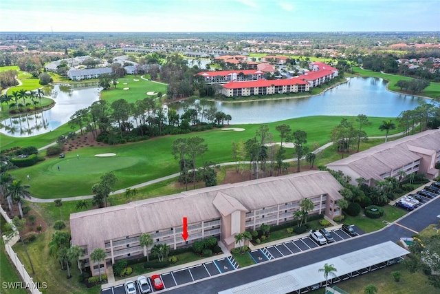 birds eye view of property with view of golf course and a water view