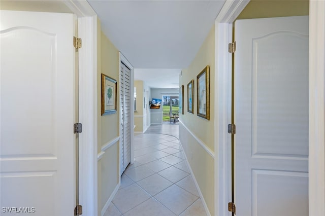 hall with light tile patterned flooring and baseboards