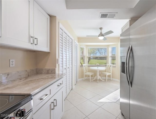 kitchen featuring white cabinets, light tile patterned floors, visible vents, and stainless steel refrigerator with ice dispenser