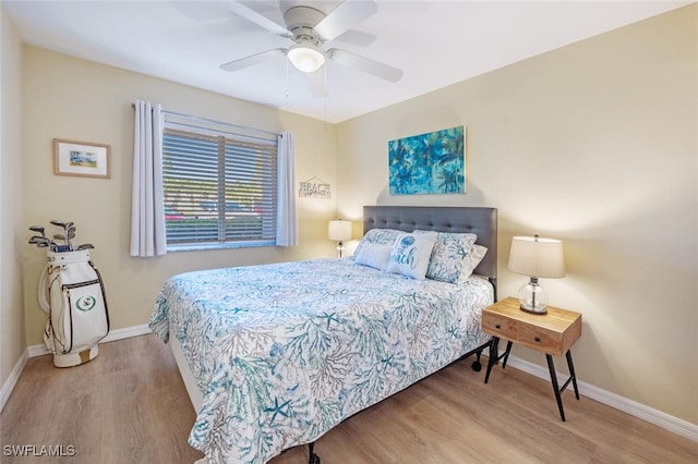 bedroom featuring a ceiling fan, baseboards, and wood finished floors