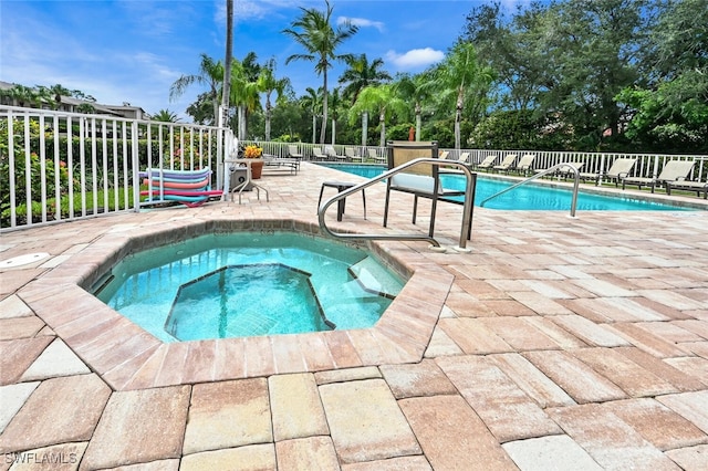 community pool with a community hot tub, a patio area, and fence