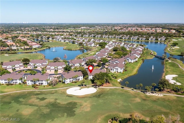 drone / aerial view featuring a residential view, golf course view, and a water view