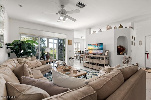 living area featuring light tile patterned floors, visible vents, and a ceiling fan