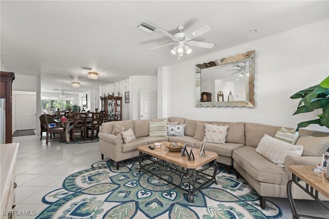 living room with light tile patterned floors, visible vents, and ceiling fan