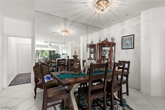 dining space featuring light tile patterned floors, a notable chandelier, and baseboards