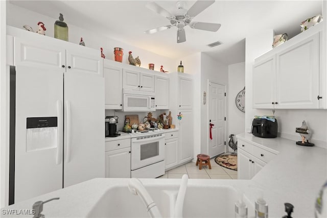 kitchen featuring white appliances, white cabinets, and light countertops