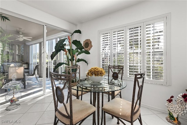 tiled dining room featuring a ceiling fan and baseboards