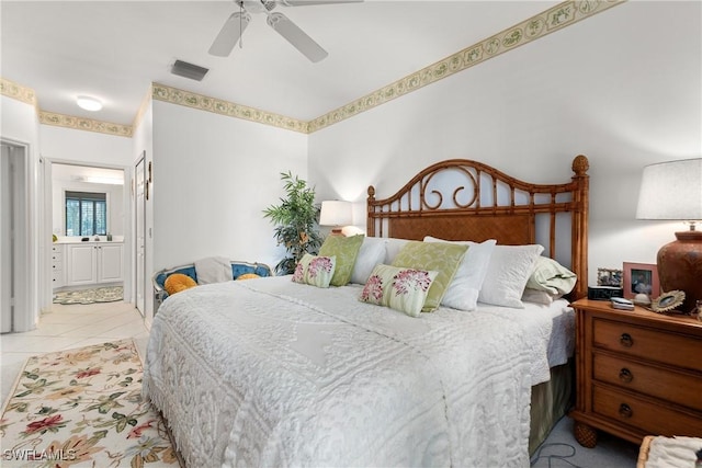 bedroom featuring tile patterned floors, visible vents, ensuite bath, and ceiling fan