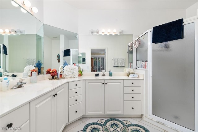 full bath featuring tile patterned flooring, double vanity, a stall shower, and a sink