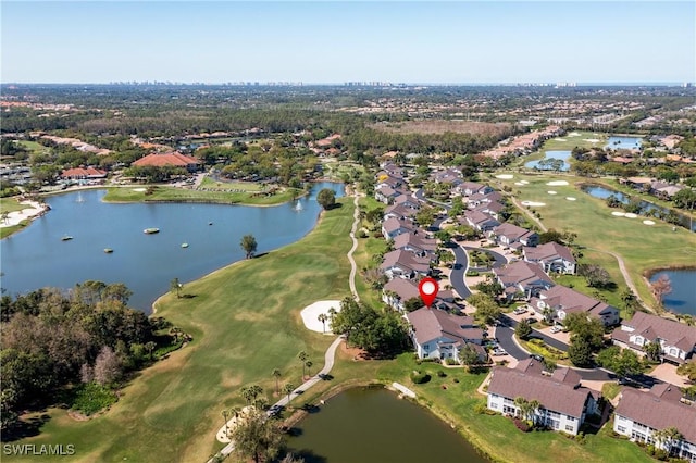 drone / aerial view with a residential view, view of golf course, and a water view