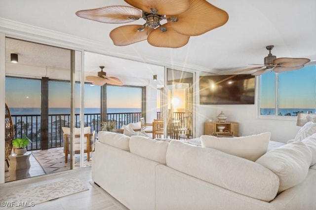 living area with ceiling fan and ornamental molding