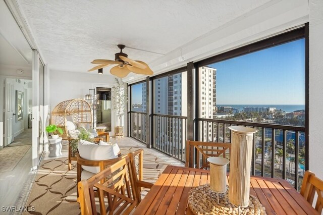 sunroom featuring a city view and ceiling fan