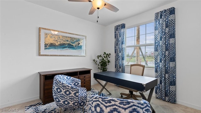 office space with baseboards and ceiling fan