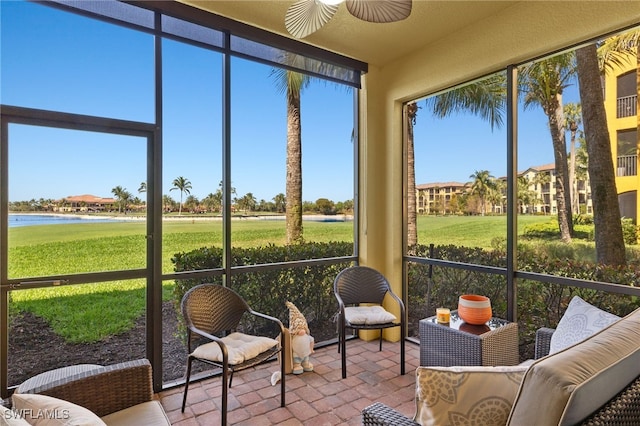 sunroom featuring a water view