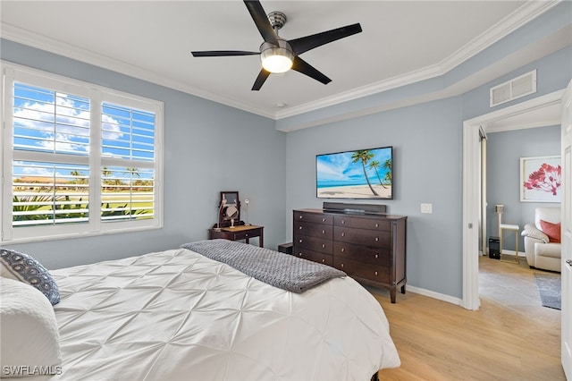 bedroom with visible vents, a ceiling fan, wood finished floors, crown molding, and baseboards