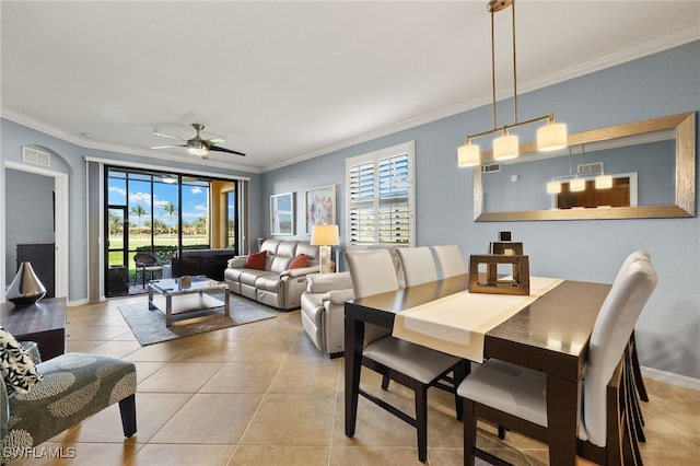 dining area featuring light tile patterned floors, baseboards, crown molding, and a ceiling fan