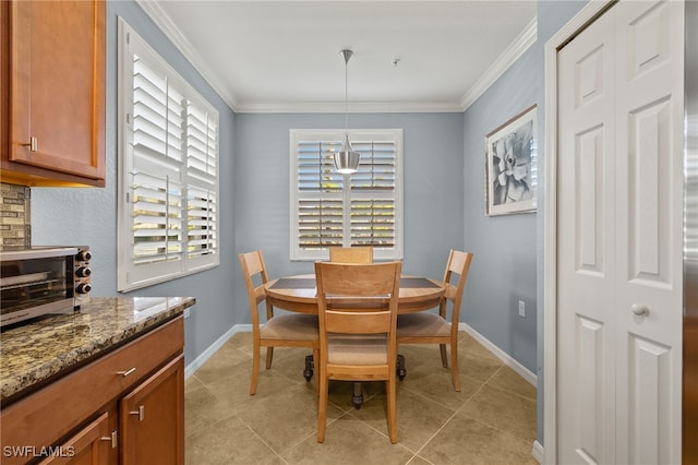 dining room featuring light tile patterned flooring, a toaster, baseboards, and ornamental molding