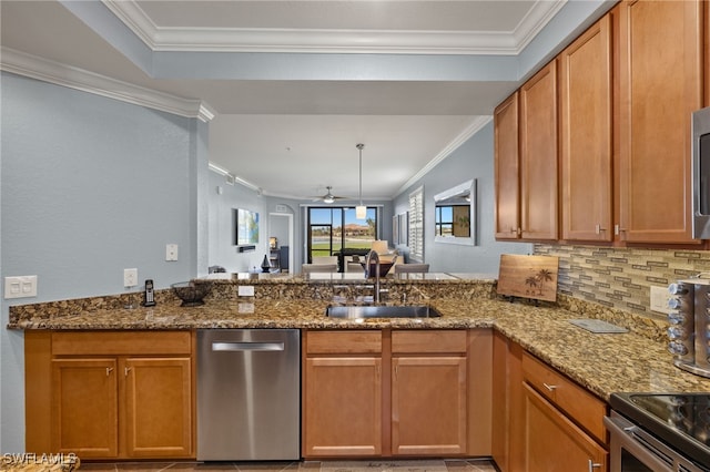 kitchen with stone counters, a peninsula, stainless steel appliances, decorative backsplash, and a sink