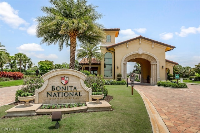 view of home's community featuring decorative driveway and a yard