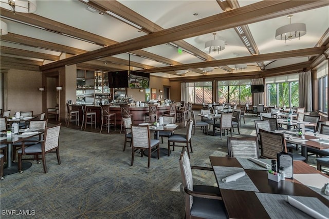 carpeted dining space with beam ceiling