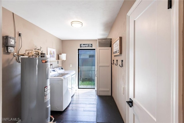 washroom featuring dark wood finished floors, laundry area, washing machine and dryer, and electric water heater