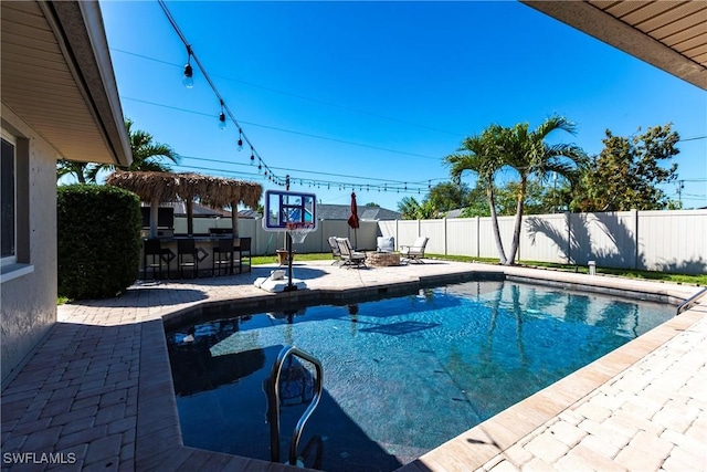 view of pool with outdoor dry bar, a patio area, a fenced backyard, and a fenced in pool