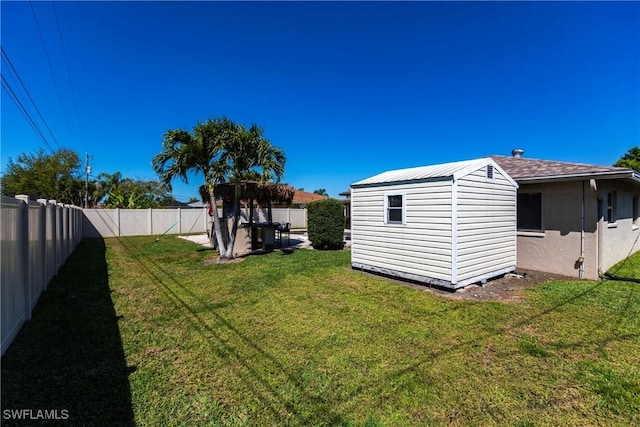 view of yard featuring an outdoor structure, a storage unit, and a fenced backyard