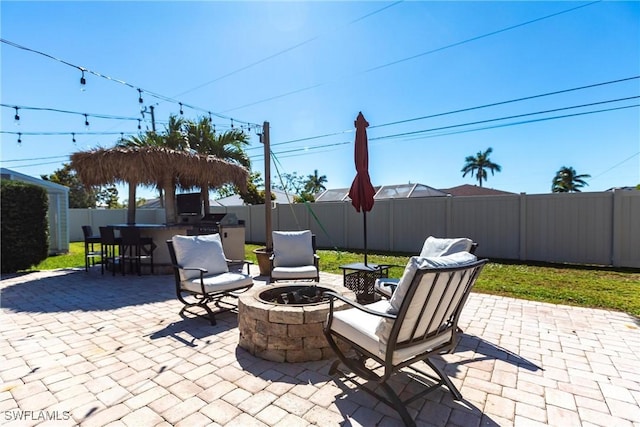 view of patio with a fire pit, a fenced backyard, and outdoor dining space