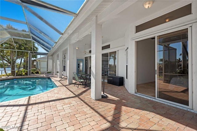 outdoor pool with a patio area, a lanai, and a ceiling fan