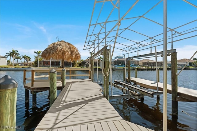 dock area featuring boat lift and a water view