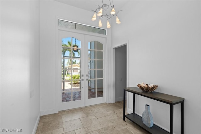 doorway to outside with stone tile flooring, french doors, baseboards, and a chandelier