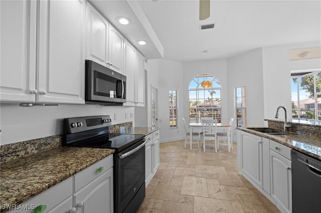 kitchen with visible vents, stainless steel microwave, range with electric stovetop, stone tile floors, and black dishwasher