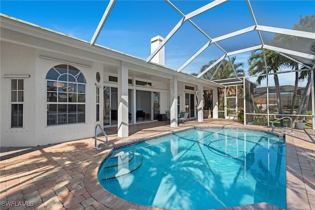 outdoor pool featuring a patio area, glass enclosure, and ceiling fan