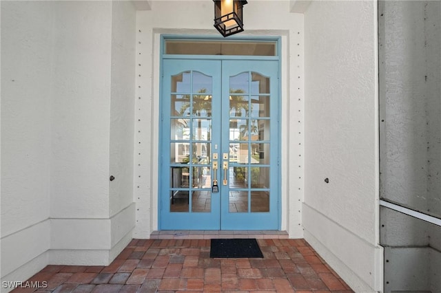 view of exterior entry with stucco siding and french doors