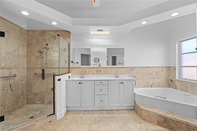 bathroom with recessed lighting, a shower stall, a garden tub, and a sink